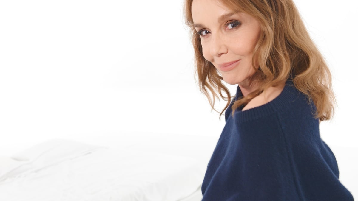 A model in a navy top against a white background in HAUS LABS campaign imagery